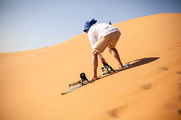 Sandboarding in Merzouga Erg chebbi desert of Morocco